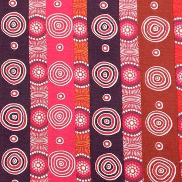 A close-up of a fabric pattern featuring vertical stripes with circular and spiral dot designs in pink, red, orange, brown, and dark purple.