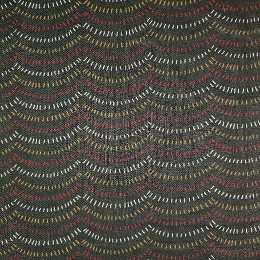 A close-up of a woven fabric with a dark charcoal gray base and repeating wavy horizontal lines in white, muted red, and mustard yellow.