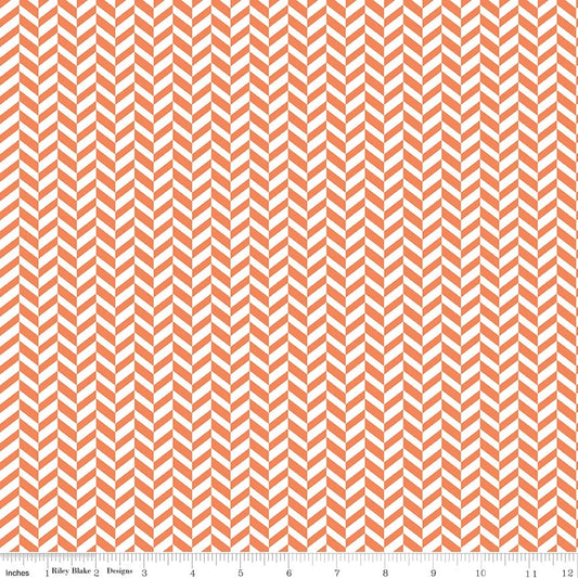 A close-up of a repeating chevron pattern in coral orange and white, with a small ruler strip along the bottom edge showing scale.