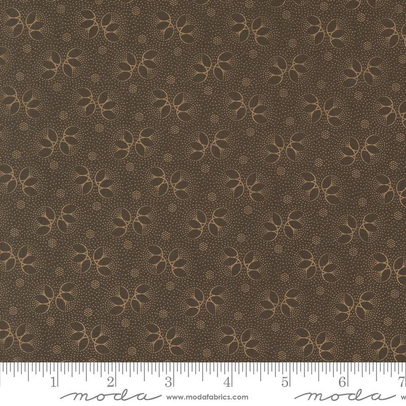 Brown fabric with a repeating tan floral and dotted pattern, shown flat with a measuring ruler along the bottom edge and Moda Fabrics branding.