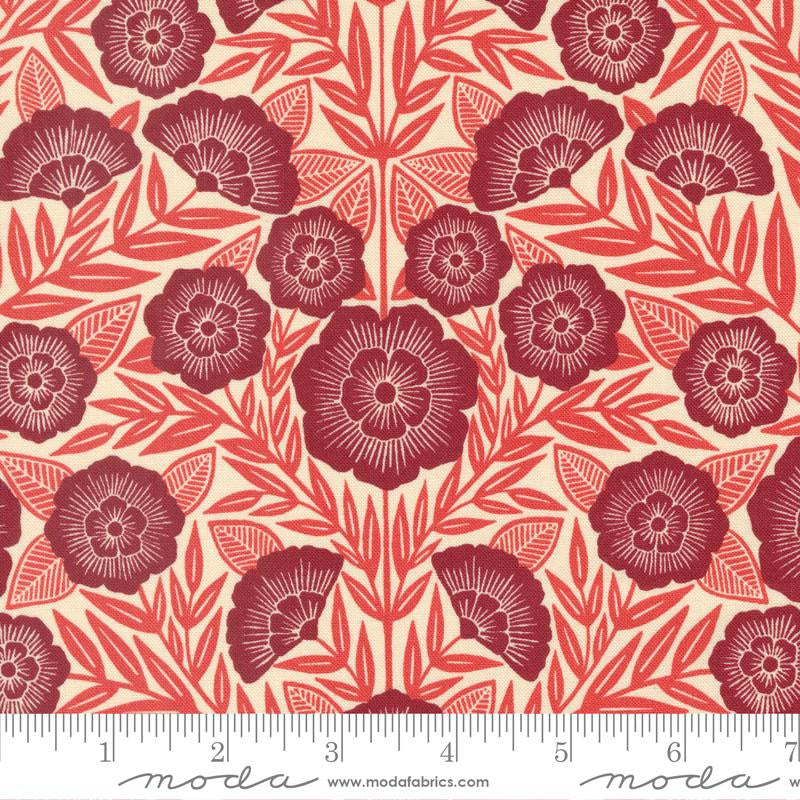 A repeating floral pattern fabric swatch featuring dark red stylized flowers and leaves on a warm cream background, with a measuring ruler along the bottom edge showing the scale.