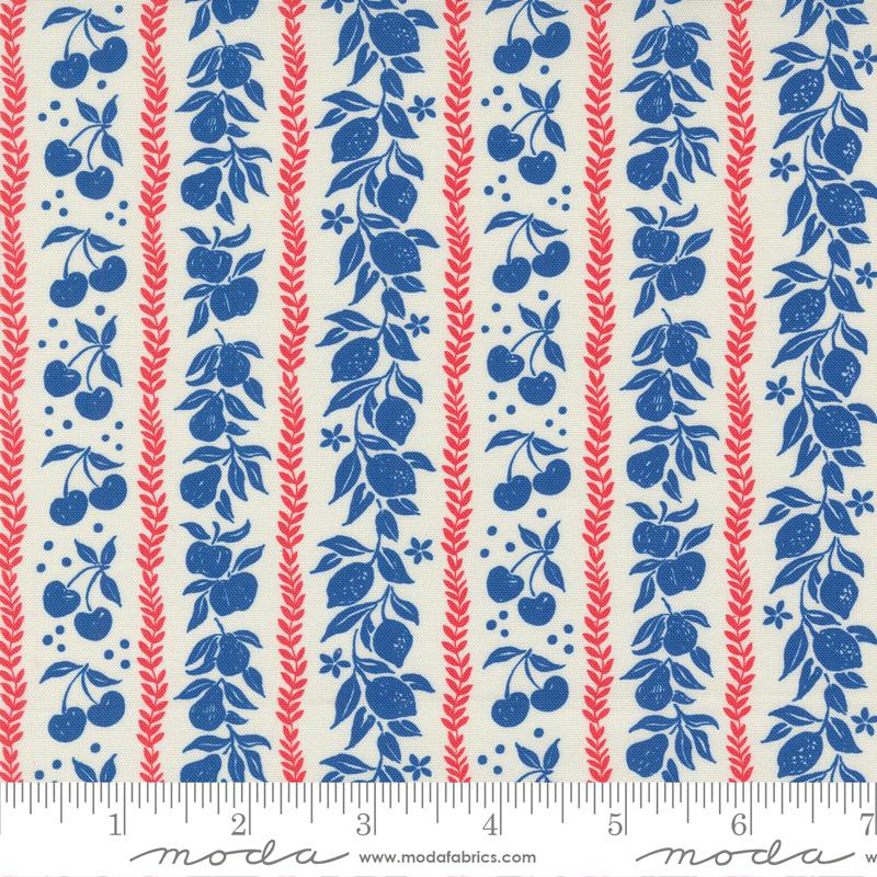 A close-up of a fabric pattern featuring vertical stripes with blue fruit and leaf motifs, red wheat-like stalks, and small blue dots on an off-white background. A ruler and the Modas fabric brand name are visible along the bottom edge.