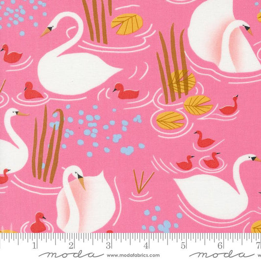 Pink fabric with a repeating pattern of white swans, red ducks, yellow lily pads, and blue water splashes, shown with a ruler at the bottom indicating scale. The brand name 'moda fabrics' is printed along the bottom edge.