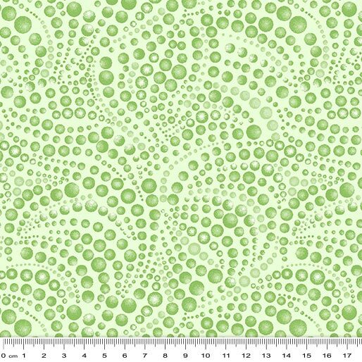 Light green fabric with a repeating pattern of hand-drawn green circles in various sizes, shown with a white ruler at the bottom indicating scale.