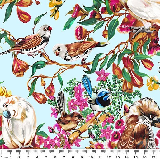 A repeating illustrated pattern of birds, flowers, and leaves on a pale blue background, with a measuring ruler along the bottom edge to show scale.