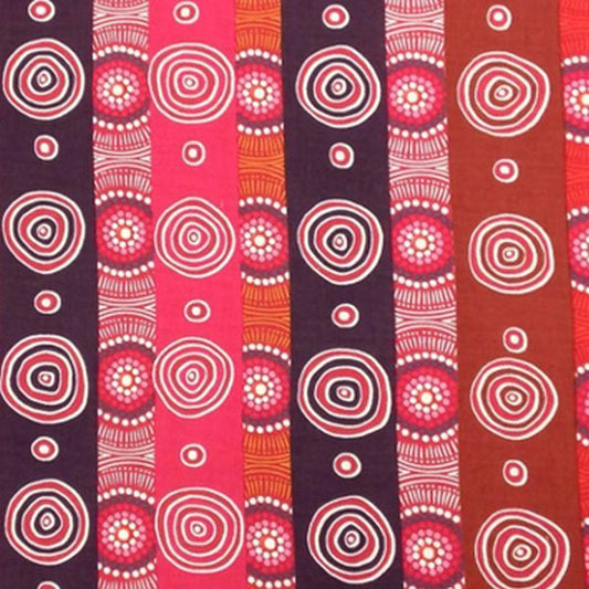 A close-up of a fabric pattern featuring vertical stripes with circular and spiral dot designs in pink, red, orange, brown, and dark purple.