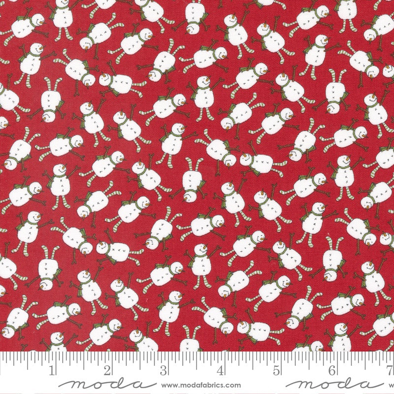 Red fabric with a repeating pattern of white snowmen and candy canes, shown with a white ruler along the bottom edge displaying measurements.