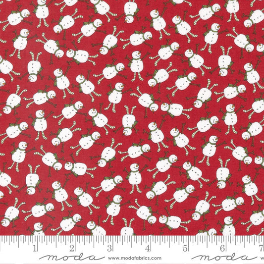 Red fabric with a repeating pattern of white snowmen and candy canes, shown with a white ruler along the bottom edge displaying measurements.