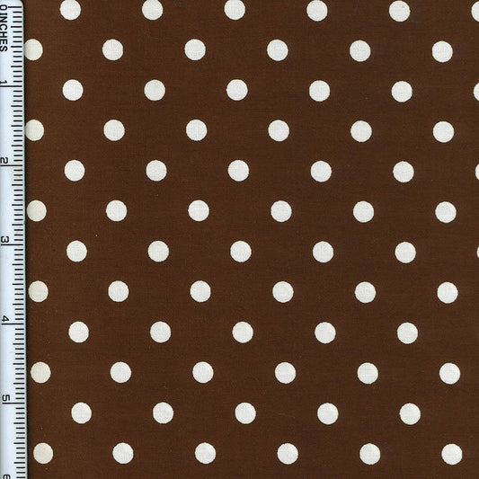 Brown fabric with a white polka dot pattern, shown flat with a ruler on the left edge for scale.