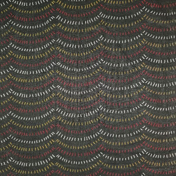 A close-up of a woven fabric with a dark charcoal gray base and repeating wavy horizontal lines in white, muted red, and mustard yellow.