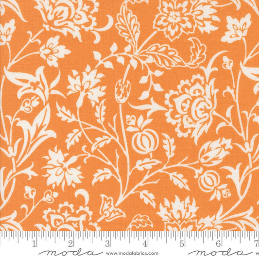 A close-up of a fabric pattern featuring a white floral and botanical print on a bright orange background, with a white ruler along the bottom edge showing scale. The brand name 'moda fabrics' is printed at the bottom.