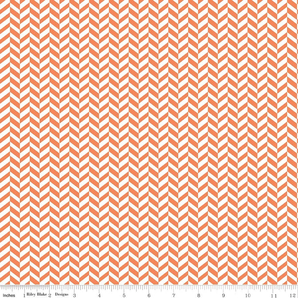 A close-up of a repeating chevron pattern in coral orange and white, with a small ruler strip along the bottom edge showing scale.