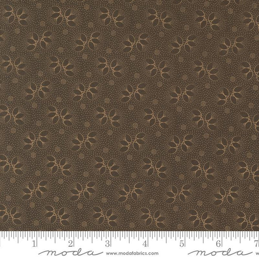 Brown fabric with a repeating tan floral and dotted pattern, shown flat with a measuring ruler along the bottom edge and Moda Fabrics branding.