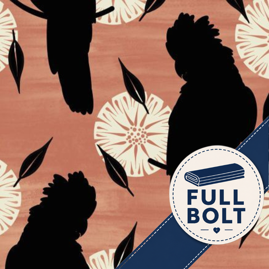A close-up of fabric with a terracotta background, black cockatoos silhouettes, cream floral motifs, and a blue diagonal stripe. A circular badge in the lower right reads “FULL BOLT.