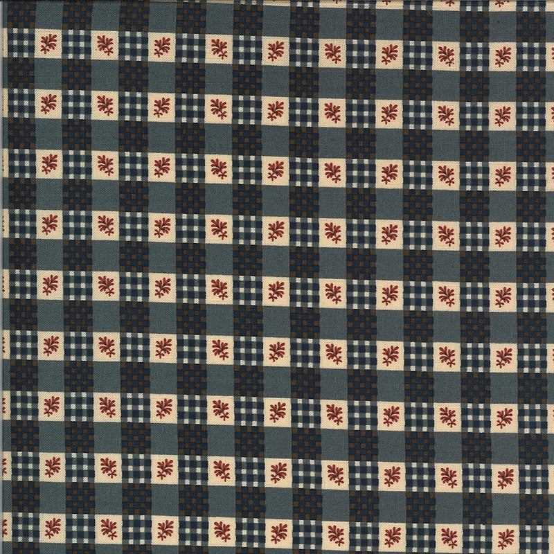 A close-up of a fabric pattern featuring a checkered grid of navy blue, slate blue, beige, and white squares, with small red floral motifs in the center of the beige squares.