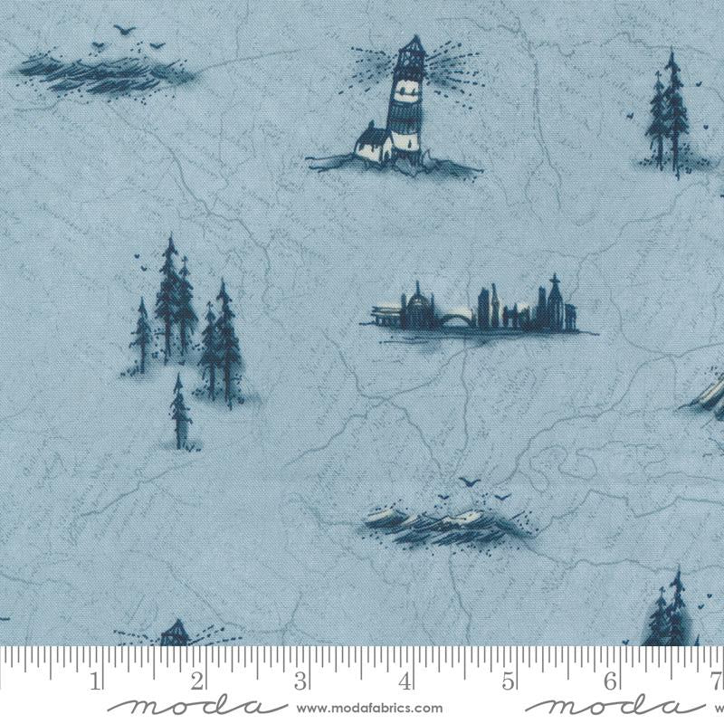 Light blue fabric with a repeating pattern of dark blue lighthouses, trees, and city silhouettes, shown with a ruler at the bottom indicating scale. The brand name 'Moda Fabrics' is visible on the ruler.