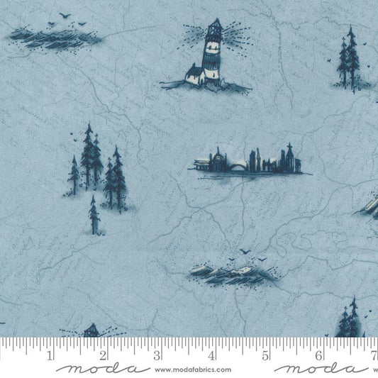 Light blue fabric with a repeating pattern of dark blue lighthouses, trees, and city silhouettes, shown with a ruler at the bottom indicating scale. The brand name 'Moda Fabrics' is visible on the ruler.