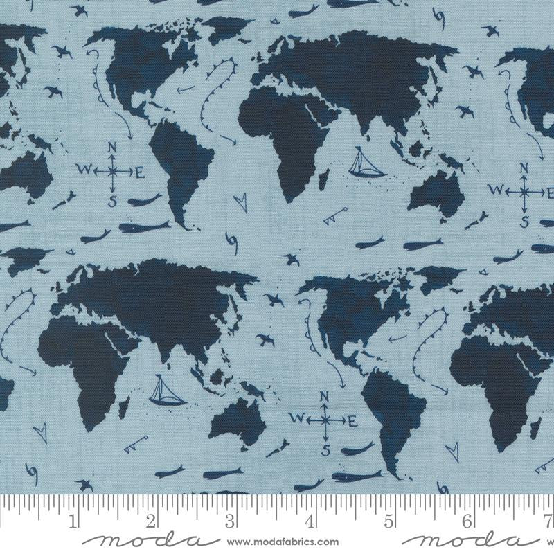 Light blue fabric with a navy world map pattern, featuring compass roses, sailboats, and small ships. A measuring ruler is visible along the bottom edge.