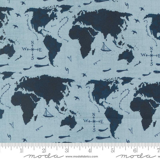 Light blue fabric with a navy world map pattern, featuring compass roses, sailboats, and small ships. A measuring ruler is visible along the bottom edge.