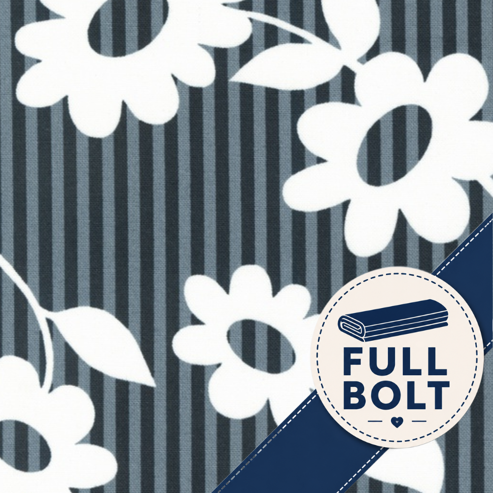 A close-up of fabric showing a navy and gray vertical stripe background with large white floral motifs. A circular badge in the lower right reads “FULL BOLT” with a folded fabric icon and a dark blue diagonal band across the corner.