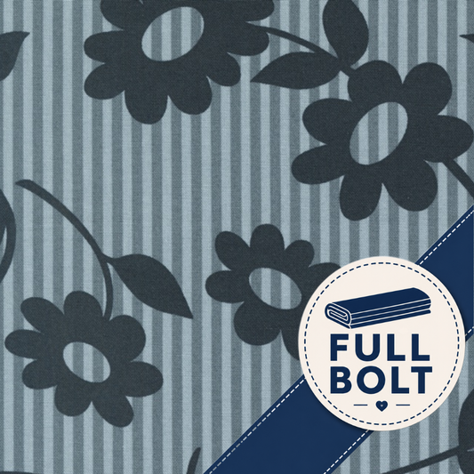 A close-up of fabric showing a blue and gray striped background with dark navy floral motifs and a diagonal navy band. A circular badge in the lower right reads “FULL BOLT.