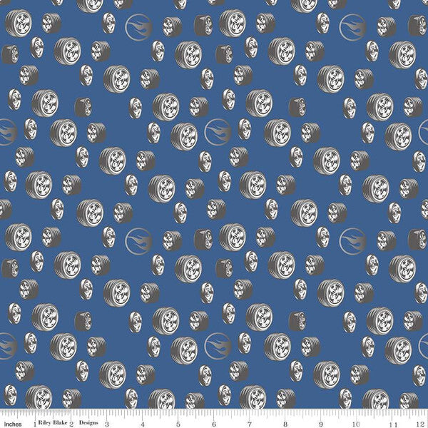 A repeating pattern of silver and white stylized wheels and tyres  with hot wheels logoson a medium blue background, with a small ruler scale along the bottom edge.