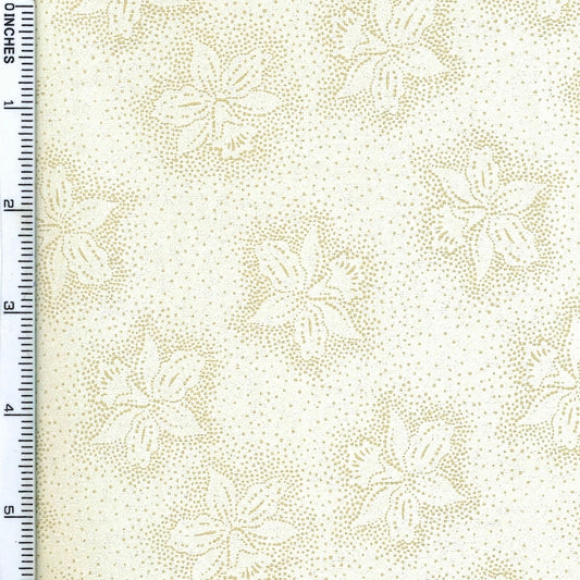 A close-up of a fabric pattern featuring cream-colored floral motifs with gold dotted outlines and a dense gold speckled background, with a ruler on the left side indicating inches.