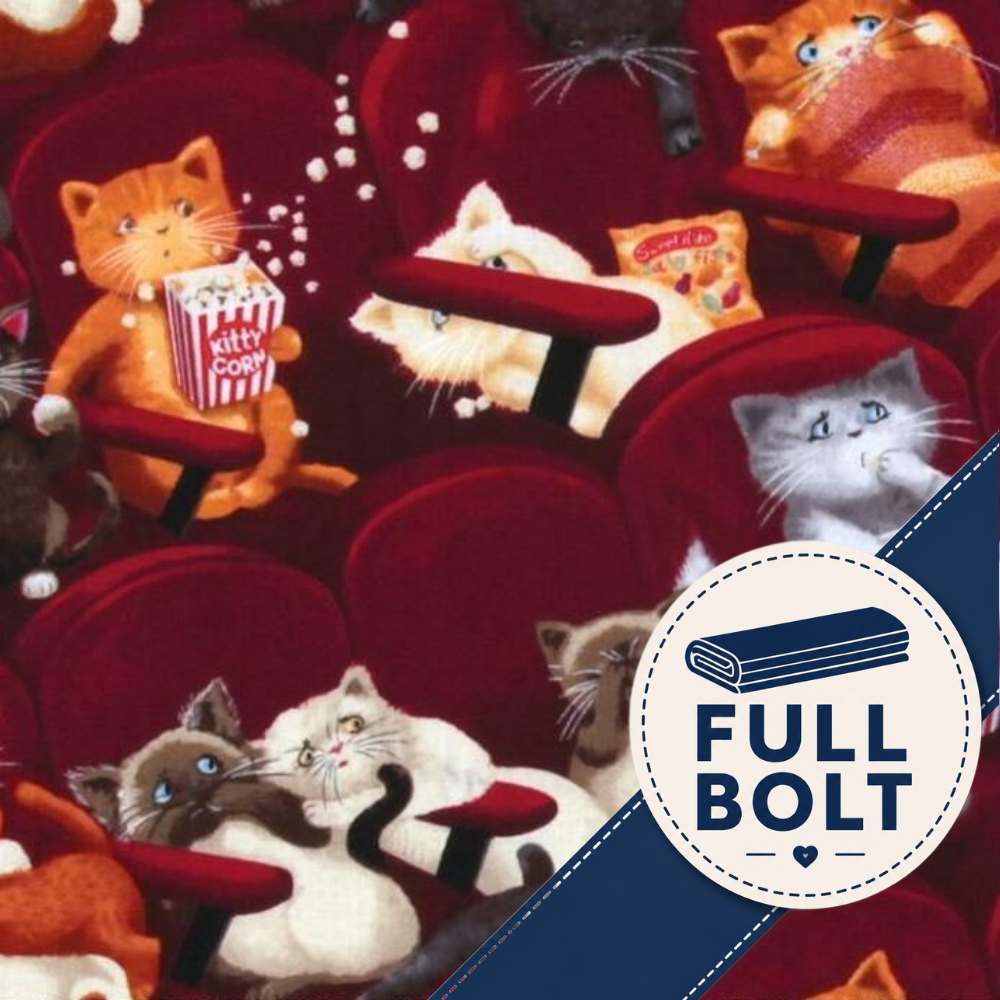 A close-up of fabric featuring a playful print of cats sitting in red theater seats, holding popcorn and snacks, with a blue diagonal banner in the lower right that reads 'FULL BOLT' inside a white circle.