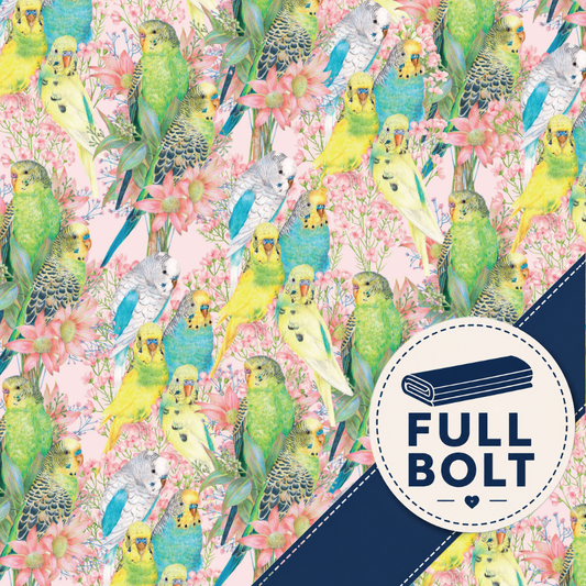 A repeating fabric pattern of colourful budgerigars in green, yellow, blue, and gray among pink flowers on a pale pink background, with a dark navy diagonal band and a circular badge reading FULL BOLT.
