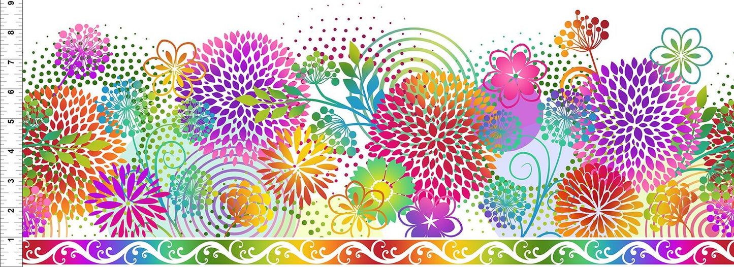 A vibrant, multicolor floral fabric pattern featuring stylized dandelions, leaves, and abstract dots in rainbow hues, with a decorative rainbow border along the bottom and a white inch ruler scale on the left side.