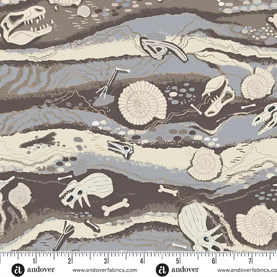 Fabric pattern with dinosaur fossils and bones on a rock formation background, featuring Andover Fabrics branding and ruler.