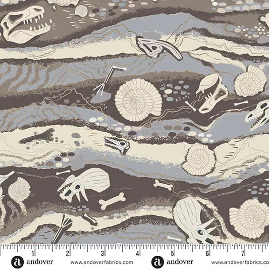 Fabric pattern with dinosaur fossils and bones on a rock formation background, featuring Andover Fabrics branding and ruler.