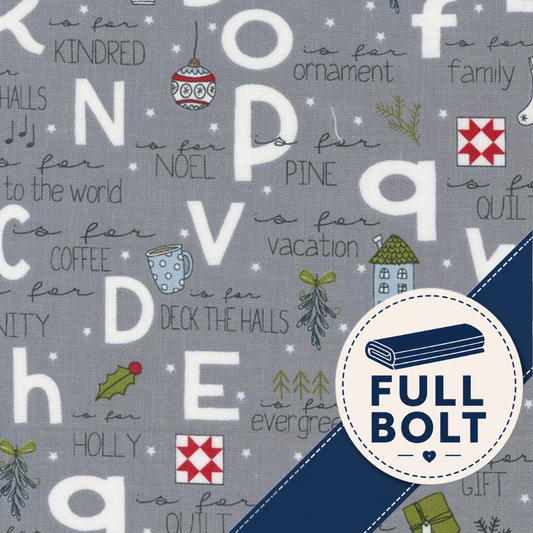A close-up of a gray fabric with a festive holiday alphabet print, featuring letters, Christmas ornaments, trees, and phrases like 'is for Noel' and 'is for gift'. A navy blue diagonal band and a circular white badge reading 'FULL BOLT' are overlaid on the lower right.