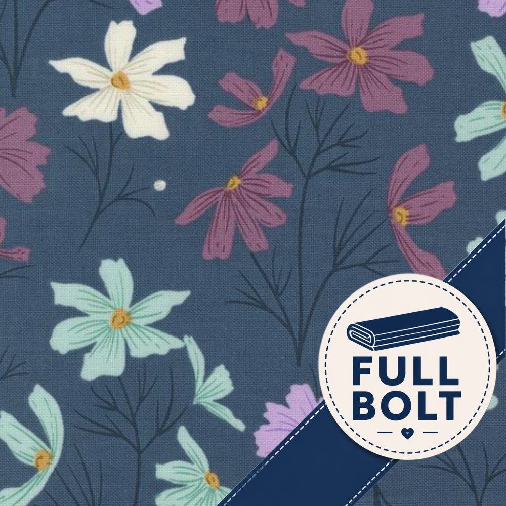 A close-up of a floral fabric pattern on a dark blue background, with white, mint, and mauve flowers and a circular badge that reads “FULL BOLT.”.
