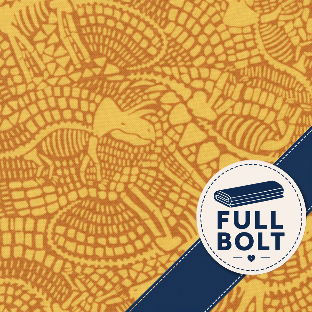 A close-up of patterned fabric with a mustard yellow and orange abstract design, overlaid with a navy diagonal band and a white circular badge reading FULL BOLT with an icon of a folded fabric bolt.