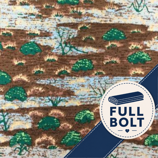 A close-up of a printed fabric pattern showing brown ground with green shrubs and pale blue and beige horizontal streaks. A dark blue diagonal banner overlays the lower right corner, with a circular badge reading “FULL BOLT.