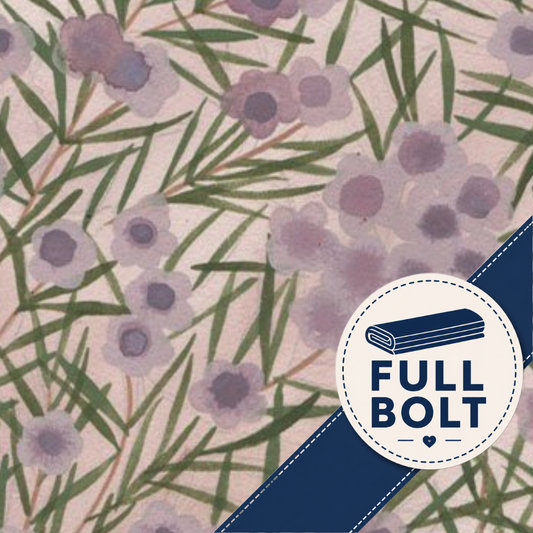 A close-up of a fabric pattern featuring purple flowers and green leaves on a light pink background, with a navy blue diagonal banner in the lower right corner containing a white circular badge that reads 'FULL BOLT'.