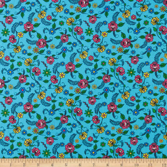 A close-up of a fabric pattern featuring a turquoise blue background with a dense, repeating floral print of pink, yellow, and blue flowers with green leaves and vines. A wooden ruler is visible along the bottom edge to show scale.